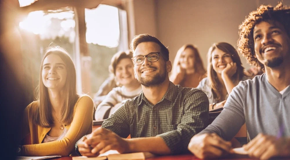 Students sitting and smiling at teacher