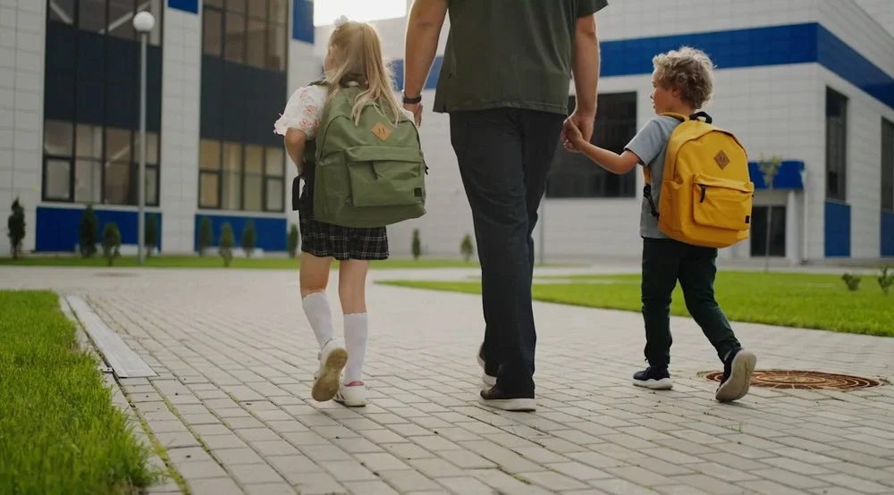 Children walking to school door with parent